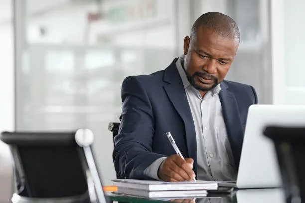 Responsable prenant des notes au cours d'un travail d'analyse